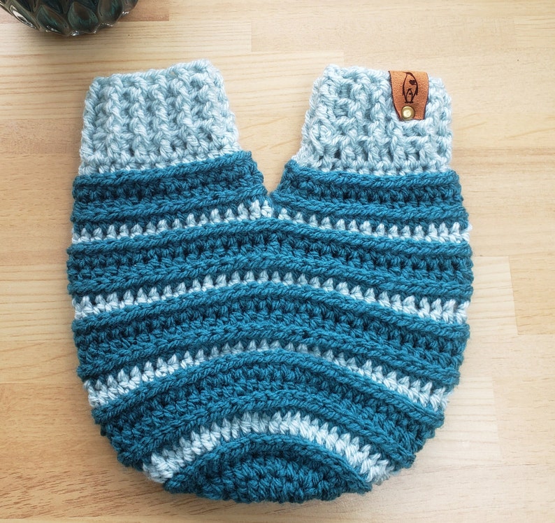 A crochet mitten with two openings for a couple tohold hands