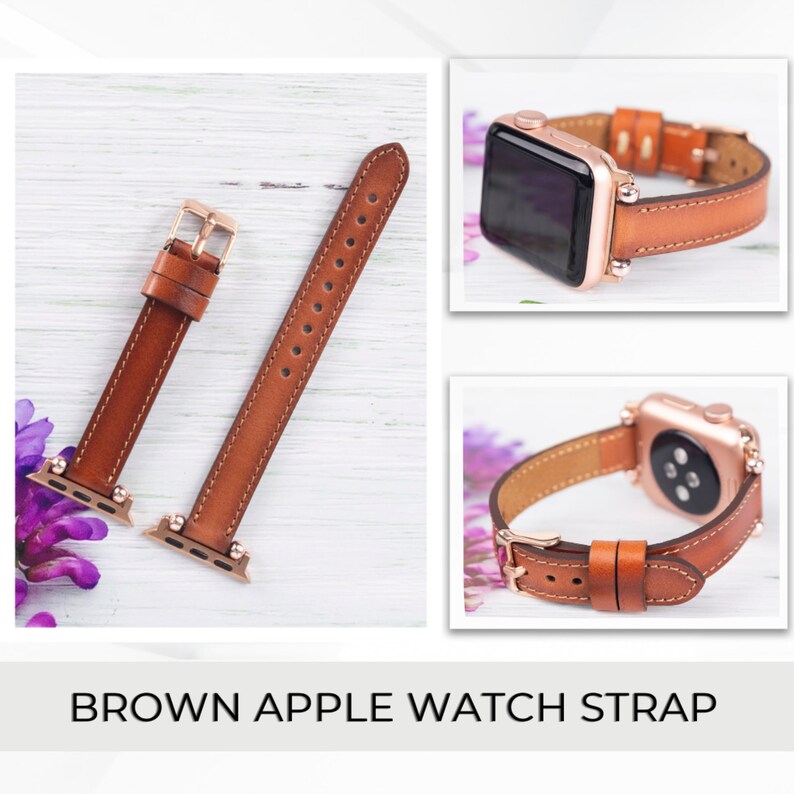 May include: Brown leather Apple Watch strap with gold hardware. The strap is shown on a white wooden surface.