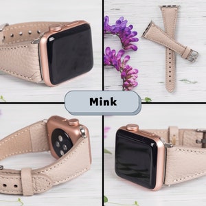 Puede incluir: Una correa de Apple Watch de cuero beige claro con una esfera de reloj de oro rosa. La correa se muestra en cuatro posiciones diferentes sobre una superficie de madera blanca. La palabra "Mink" est&aacute; escrita en un cuadro azul claro.