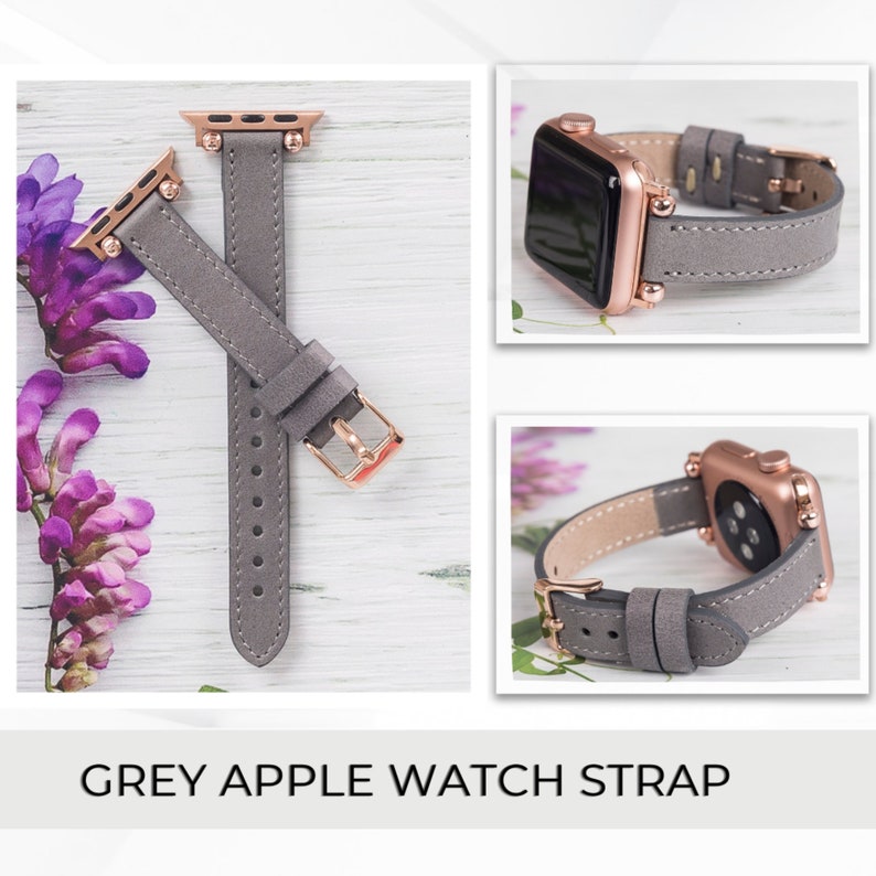May include: A grey leather Apple Watch band with rose gold hardware. The band is shown on a white wooden surface with purple flowers.