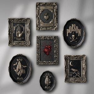 Peut inclure: Une collection de huit d&eacute;corations murales encadr&eacute;es sur le th&egrave;me gothique et effrayant. Les cadres sont orn&eacute;s et pr&eacute;sentent des accents noirs et dor&eacute;s. Les images &agrave; l'int&eacute;rieur des cadres comprennent une main avec le texte "Palmistry Guide", un c&oelig;ur, un cr&acirc;ne et des os crois&eacute;s avec le texte "Poison", un fant&ocirc;me avec le texte "Big Boo", un corbeau et une lune croissante.