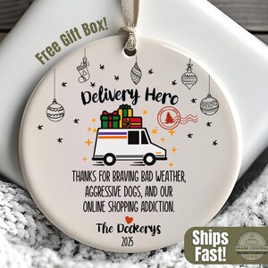 Op de afbeelding: Een witte keramische kerstbal met een bestelwagenafbeelding, de tekst "Delivery Hero" en de woorden "Bedankt voor het trotseren van slecht weer, agressieve honden en onze online shoppingverslaving."