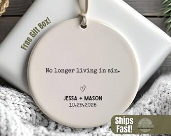 Peut inclure: Ornement rond en céramique blanc cassé avec le texte "No longer living in sin." et les noms JESSA + MASON avec la date 10.29.2025. L'ornement a un ruban pour l'accrocher et est présenté sur une boîte cadeau blanche.