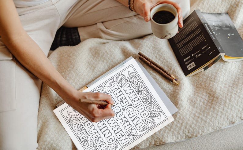 May include: A black and white colouring page with a mandala design and the text "Why do they call it rush hour when nothing moves?"