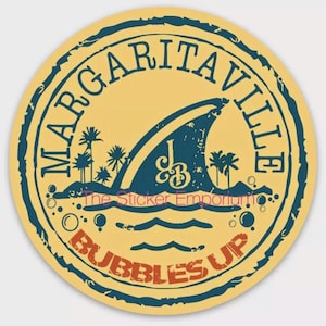 May include: A yellow circle sticker with a blue border and the text "Margaritaville" in a blue circular font. Inside the circle is a blue shark fin with the text "JB" in a white circular font. Below the shark fin is a blue wave and the text "Bubbles Up" in a red circular font.