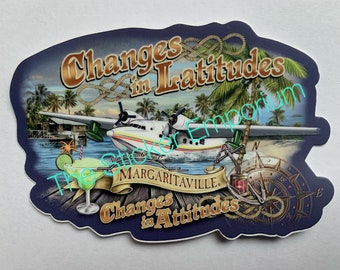 May include: A blue and white sticker featuring a seaplane flying over a tropical island. The sticker reads "Changes in Latitudes Changes in Attitudes" and "Margaritaville".