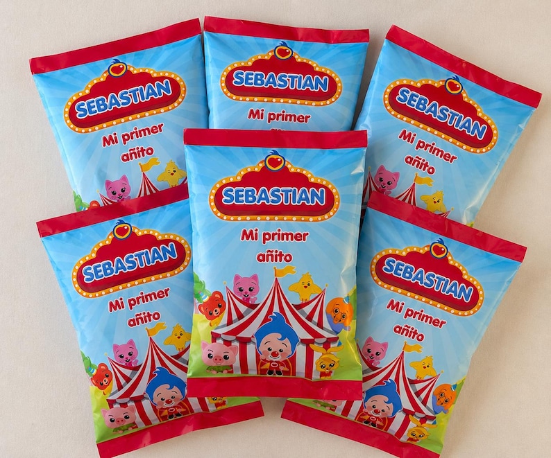 May include: Six blue party favor bags with red trim. Each bag features the name "SEBASTIAN" in a gold and red marquee design, with the text "Mi primer a&ntilde;ito" below. The bags have a circus theme with cartoon characters.