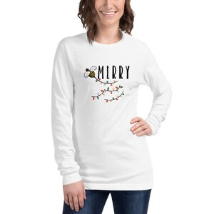May include: White long-sleeve t-shirt with a bee and string of lights graphic and the text "MERRY".