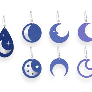 May include: A collection of seven celestial-themed earrings. The earrings feature various moon phases and star designs in shades of blue and silver. Each earring hangs from a silver hook, showcasing a unique celestial shape.