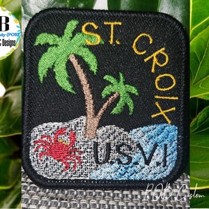 May include: Embroidered patch with a black background featuring a palm tree, a crab, and the text "ST. CROIX US.VI".