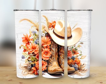 Könnte beinhalten: Ein weißer Becher mit einem Design aus Cowboystiefeln, einem Cowboyhut und orangefarbenen Blumen auf einem weißen Holzmaserungshintergrund.