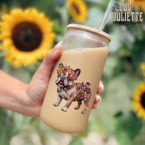 Puede incluir: Un vaso reutilizable de vidrio con tapa marr&oacute;n y una pajita. El vaso tiene un dise&ntilde;o floral de un bulldog franc&eacute;s con una corona de flores.