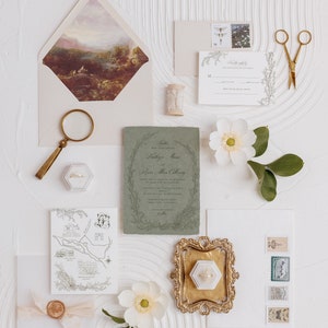 May include: Wedding invitation suite with a green and white color scheme. The invitation features a floral wreath with the couple's names and wedding date. The RSVP card has a floral border and a place for guests to RSVP. The map card shows the location of the wedding venue. The suite is decorated with a wax seal, a magnifying glass, a ring box, and a sprig of white flowers.