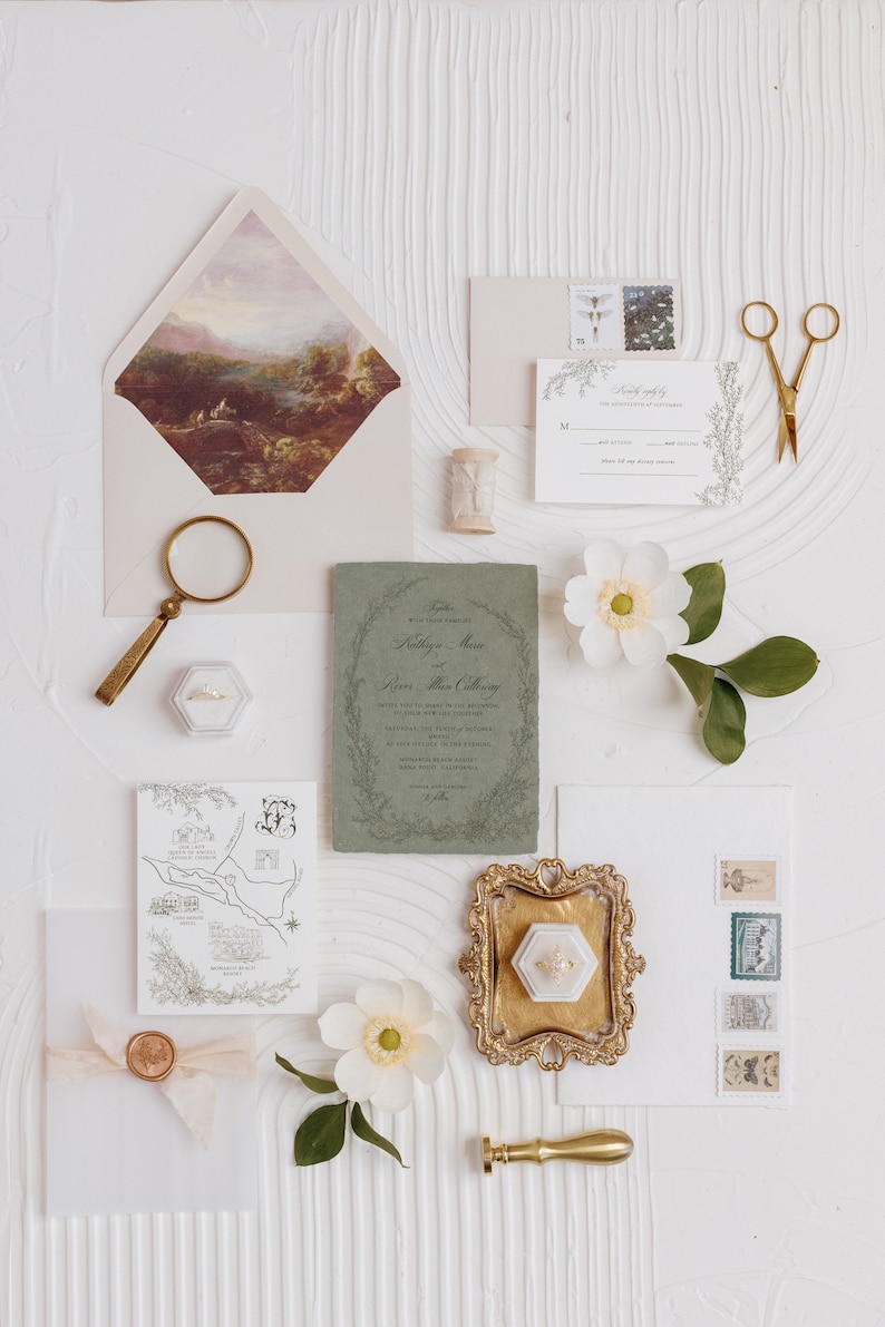 May include: Wedding invitation suite with a green and white color scheme. The invitation features a floral wreath with the couple's names and wedding date. The RSVP card has a floral border and a place for guests to RSVP. The map card shows the location of the wedding venue. The suite is decorated with a wax seal, a magnifying glass, a ring box, and a sprig of white flowers.