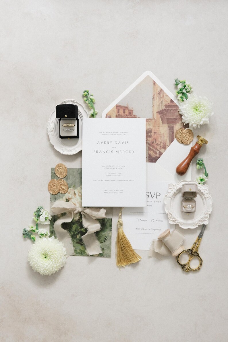 Puede incluir: Conjunto de papeler&iacute;a de boda con anillos, flores y detalles dorados. La invitaci&oacute;n dice "AVERY DAVIS y FRANCIS MERCER". Incluye una borla dorada, tijeras y sellos de cera.