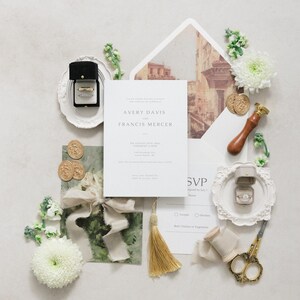 Puede incluir: Conjunto de invitaciones de boda con una tarjeta de invitaci&oacute;n central con los nombres "Avery Davis" y "Francis Mercer". El conjunto incluye anillos en cajas, detalles florales, borla dorada, sellos de cera y tijeras decorativas.
