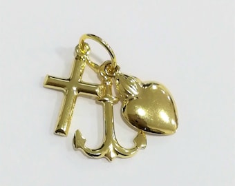 May include: Gold charm featuring a cross, anchor, and heart. The charm is made from gold metal and has a shiny finish.