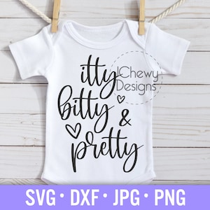 May include: White baby onesie with black text that reads "itty bitty & pretty" with a heart symbol between "bitty" and "&". The text is in a handwritten font. The onesie is hanging on a clothesline with wooden clothespins.