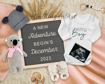 May include: A black letter board with the text "A new adventure begins December 2023". A white onesie with the text "Little Boy" in green script. A gray knitted koala toy, a gray knitted hat, and a wooden rattle are also in the image.