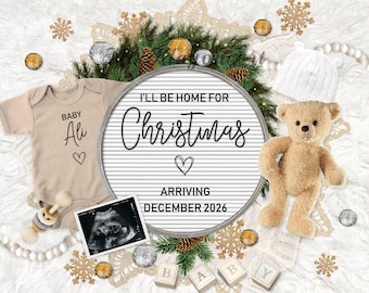 May include: A white letter board with the text "I'll be home for Christmas" and "Arriving December 2026". A tan onesie with the text "Baby Ali" and a heart is next to the letter board. A teddy bear, a white hat, and an ultrasound image are also in the image.