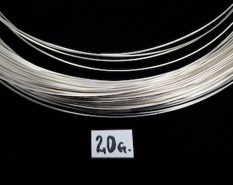 May include: A coil of silver wire, 20 grams in weight, on a black background.