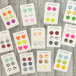 May include: Twelve sets of colorful, patterned, and textured earrings on white cards with the text "KK Designs" printed on each card. The earrings are arranged in three rows of four sets.