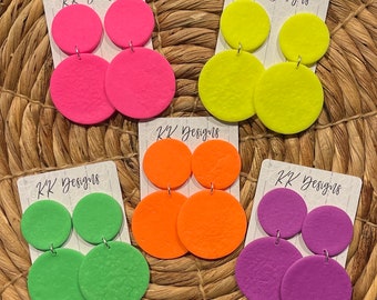 May include: Five pairs of neon colored earrings. Each pair has two round, textured earrings. The colors are pink, yellow, orange, green, and purple.
