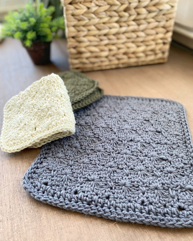 May include: Three crocheted dishcloths in different colors: cream, dark green, and gray. The dishcloths are made with a star stitch pattern.
