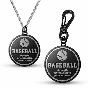 Puede incluir: Dos colgantes negros con temática de béisbol. Uno es un collar con una cadena plateada, y el otro tiene un clip negro. Ambos colgantes tienen un gráfico de béisbol y la palabra "BASEBALL" con las palabras "fuerza determinación perseverancia".