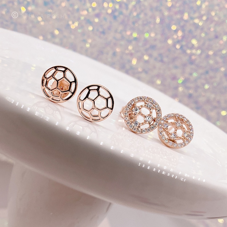 Peut inclure: Une paire de boucles d'oreilles en or rose avec un motif de ballon de football. Une boucle d'oreille est sertie de pierres de zircone cubique transparentes, tandis que l'autre est un design creux.