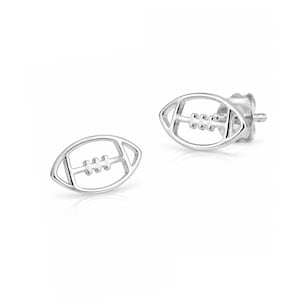 May include: A pair of silver stud earrings shaped like American footballs. Each earring features an open-work design with a central horizontal bar and three vertical stitches, finished with a post back for secure attachment to the earlobe.