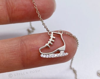 Peut inclure: Un collier argenté avec un pendentif en forme de patin à glace. Le contour du patin est en métal poli, tandis que la lame est ornée d'une rangée de petites pierres claires et scintillantes. Le pendentif est suspendu à une fine chaîne assortie.