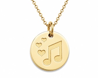 May include: A gold-toned circular pendant necklace featuring an engraved musical note symbol and three small hearts on the front surface. The pendant is suspended from a delicate matching gold-toned chain with small, uniform circular links.