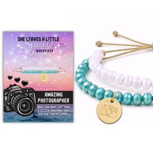 May include: Two adjustable bracelets with faceted beads in white and turquoise, featuring a gold-tone circular charm engraved with a camera icon. The display card reads: SHE LEAVES A LITTLE Sparkle WHEREVER she goes, AMAZING PHOTOGRAPHER.