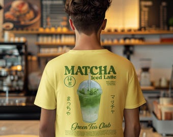 May include: A light yellow t-shirt with the words "Matcha Iced Latte" in green, along with a graphic of a green tea drink. The shirt also features Japanese text and the words "Green Tea Club".