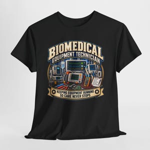 Pode incluir: Uma t-shirt preta com uma estampa gráfica de equipamentos médicos, incluindo monitores e ferramentas. O texto diz BIOMEDICAL EQUIPMENT TECHNICIAN e KEEPING EQUIPMENT RUNNING SO CARE NEVER STOPS, num design circular com ícones de engrenagens.