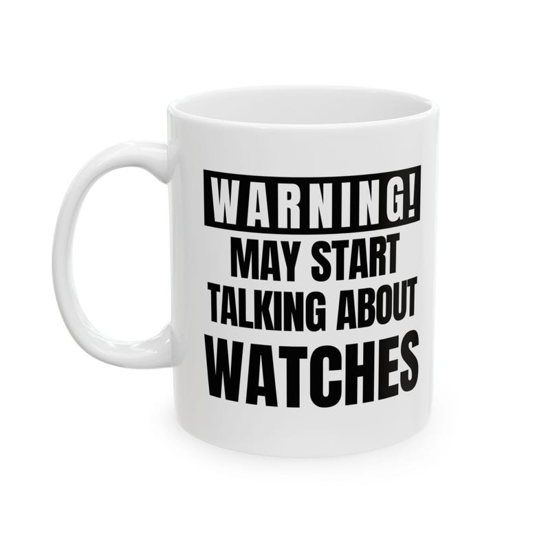 May include: White ceramic mug with a curved handle. The mug features black text that reads "WARNING! MAY START TALKING ABOUT WATCHES."