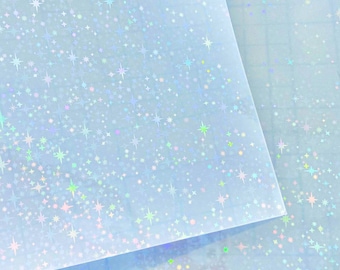 May include: A sheet of iridescent blue paper with a holographic star pattern. The paper is translucent and has a subtle shimmer.