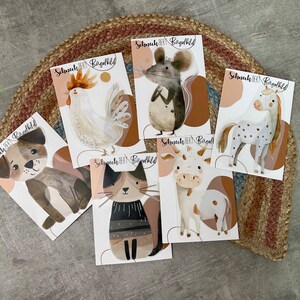 Könnte beinhalten: Sechs bunte Tieraufkleber mit dem Text "Schneck, Bert, Bagelbild" auf jedem. Die Tiere sind ein Huhn, eine Maus, ein Einhorn, eine Katze, eine Kuh und ein Hund.