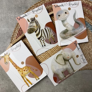 Könnte beinhalten: Vier illustrierte Tieraufkleber auf weißen Karten mit braunem und beigefarbenem Hintergrund. Die Tiere sind ein Zebra, eine Schlange, eine Giraffe und ein Elefant. Die Karten tragen den Text "Schmuck der Birgelbild".