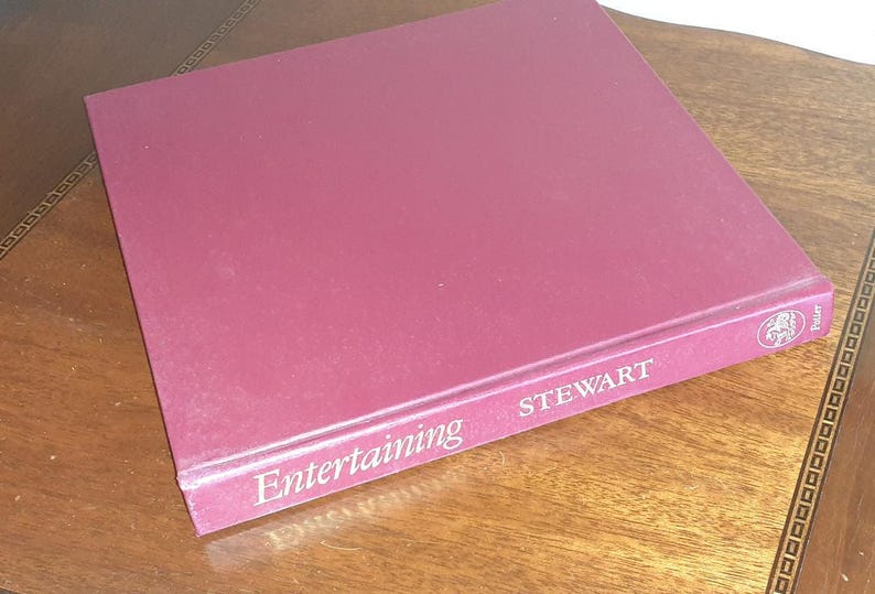 May include: A burgundy hardcover book titled "Entertaining" by Stewart, with a gold-colored design on the front cover.