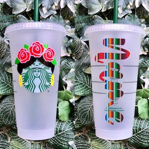 May include: Two clear plastic reusable cups with lids and straws. One cup has a colorful floral design with a Starbucks logo. The other cup has a colorful striped design with the word "Viva" written in a cursive font.