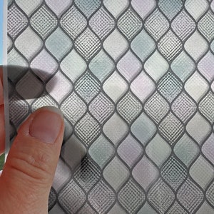 May include: A sheet of faux glass with a diamond pattern in shades of gray and white. The text "FAUX GLASS FOR DOLLHOUSE WINDOWS AND OTHER MINIATURE WORK" is at the top of the sheet. The text "whisperingruby.etsy.com" is at the bottom of the sheet.