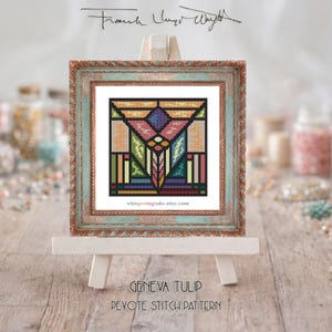 May include: A framed cross-stitch pattern with a stained-glass window design, featuring geometric shapes in orange, green, purple, and pink. The frame is a distressed teal and gold. The text "GENEVA TULIP DEVOTE STITCH PATTERN" is at the bottom.