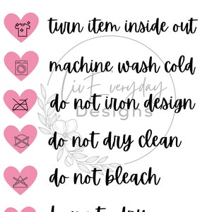 Könnte beinhalten: Rosa Herz-Symbole mit Waschhinweisen: Artikel auf links drehen, Maschinenwäsche kalt, Design nicht bügeln, nicht chemisch reinigen, nicht bleichen, zum Trocknen aufhängen.