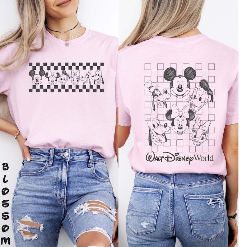 May include: A light pink t-shirt featuring black line art of Disney characters including Mickey Mouse, Minnie Mouse, Donald Duck, Daisy Duck, Goofy, and Pluto. The front displays a horizontal checkered pattern, while the back shows a larger grid with the text Walt Disney World.