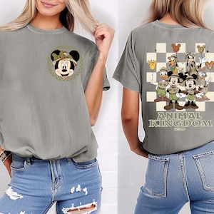 May include: Grey t-shirt with a Minnie Mouse design on the front and a Disney Animal Kingdom graphic on the back. The back design features Mickey Mouse, Donald Duck, and Goofy, with the text "ANIMAL KINGDOM EST. 1998".
