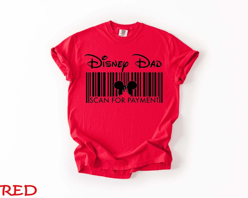 K&ouml;nnte beinhalten: Ein rotes T-Shirt mit den Worten "Disney Dad" &uuml;ber einem Barcode-Design mit Mickey Mouse Ohren. Der Text "SCAN FOR PAYMENT" befindet sich darunter. Das Wort "RED" steht unten.