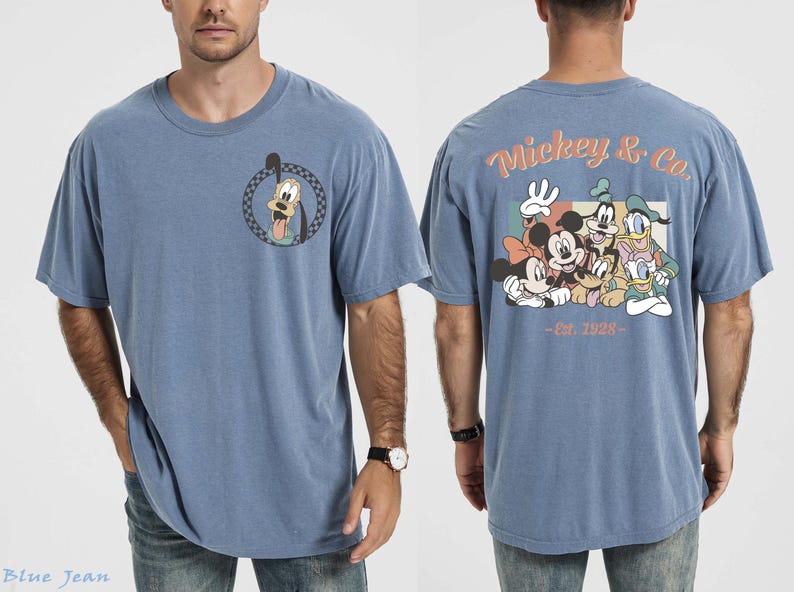 May include: A blue t-shirt featuring a cartoon of Goofy on the front and a group of Disney characters on the back. The back of the shirt has the text "Mickey & Co. - Est. 1928". The shirt is a casual style.