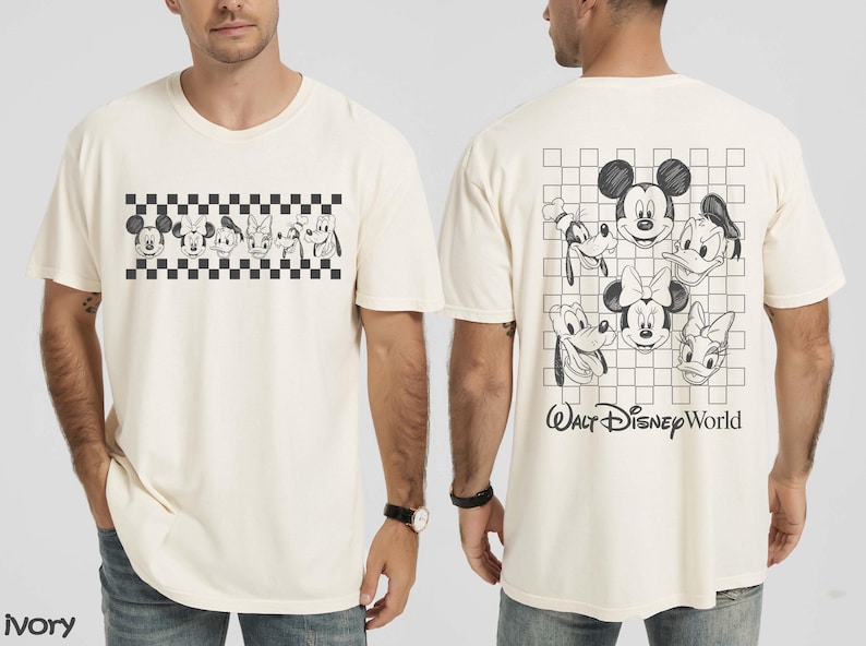 May include: An ivory short-sleeve t-shirt featuring a black and white graphic of Disney characters. The front displays a horizontal checkered strip with character faces. The back shows a larger checkered grid with character faces and the text Walt Disney World.